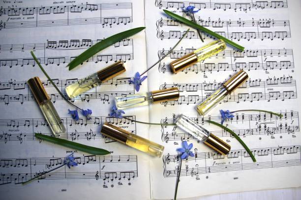 istock perfume aroma bottles with golden caps and smell, blue spring flowrs  on music note background 1392525516