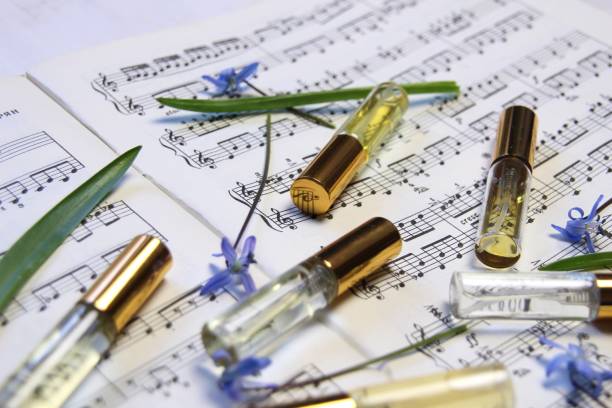 istock perfume aroma bottles with golden caps and smell, blue spring flowrs  on music note background 1392525659