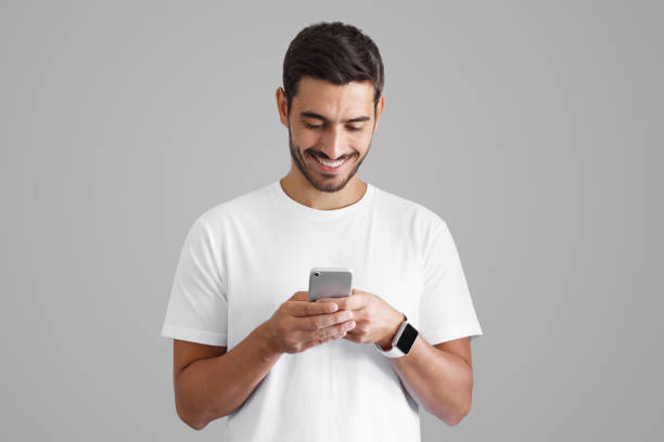 istock Young man holding smartphone with bond hands and smiling 1392528334