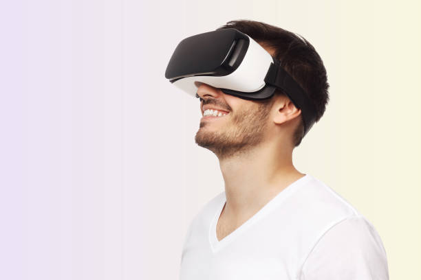 istock Young happy man smiling while enjoying and experiencing virtual reality with VR headset 1392528348