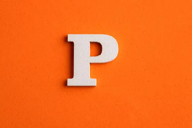 Alphabet letter P - White wood piece on orange foamy background