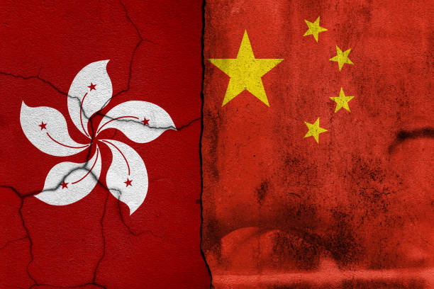 istock Broken cracked concrete wall with painted China VS Hong kong national flags. 1392529747