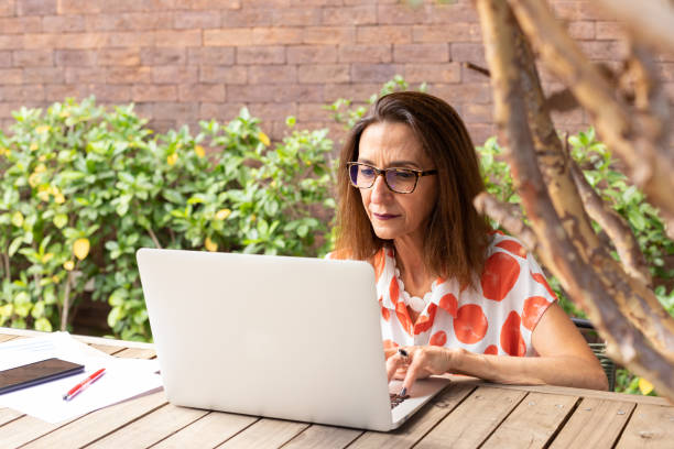 istock Mature woman working on notebook in a restaurant 1392529849