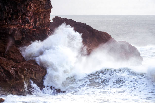 istock Big waves crashing on the rocks during a storm 1392529986
