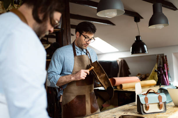 istock Caucasian male tailors, making bags and belts at tailor workshop 1392530012