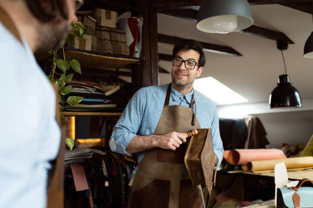 istock Male tailors, making bags and belts at tailor workshop 1392530021