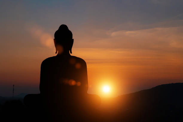 silhueta da estátua de buda ao fundo do céu do pôr do sol. conceito budista de dias sagrados. - buddhist festival - fotografias e filmes do acervo