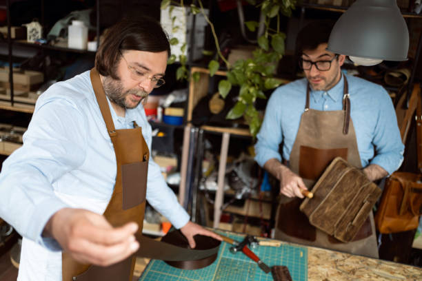 istock Male tailors, making bags and belts at tailor workshop 1392530041