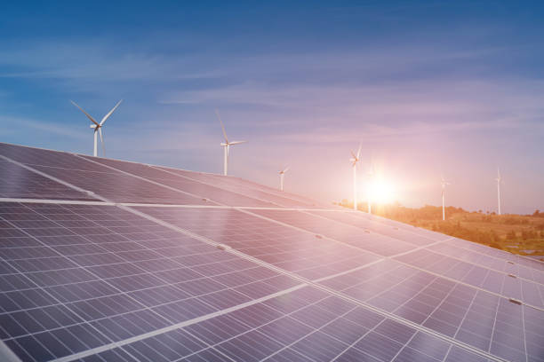 istock Solar panel and wind turbine field at sunset sky background 1392530763