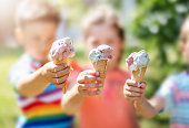 istock Group of children in the park eating cold ice cream. 1392530850