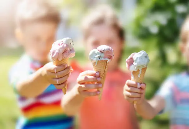 Photo of Group of children in the park eating cold ice cream.