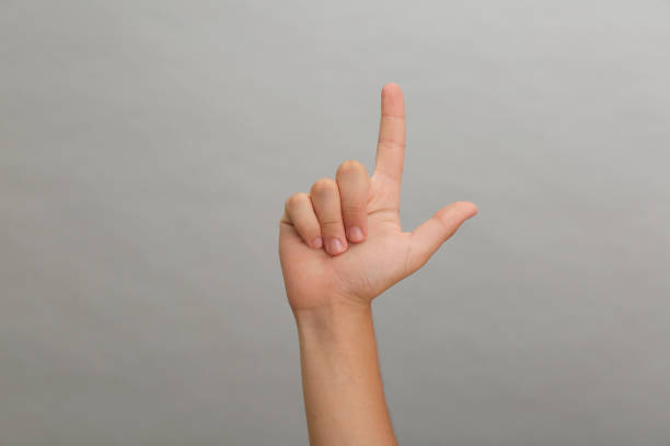 istock Teenage boy pointing at something on light grey background, closeup 1392531223