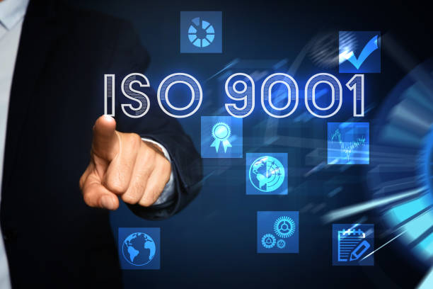 istock Man pointing at virtual screen with text ISO 9001 and different icons, closeup 1392531479