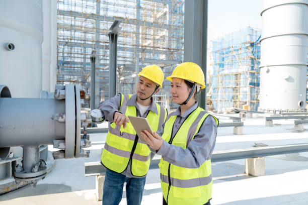 Two male and female engineers are checking equipment in the chemical plant Two male and female engineers are checking equipment in the chemical plant sewage treatment plant stock pictures, royalty-free photos & images