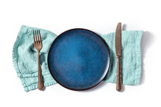 istock Cutlery with a blue plate. A fork, a knife, and a dish on a teal napkin 1392534524
