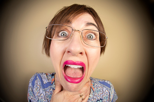 A funny fisheye image of a fearful middle age woman screaming.