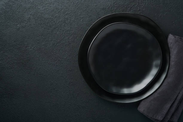 istock Ceramic empty black plate on old black ceramic cement concrete table background. Cooking stone backdrop. Top view with copy space. Flat lay 1392536827