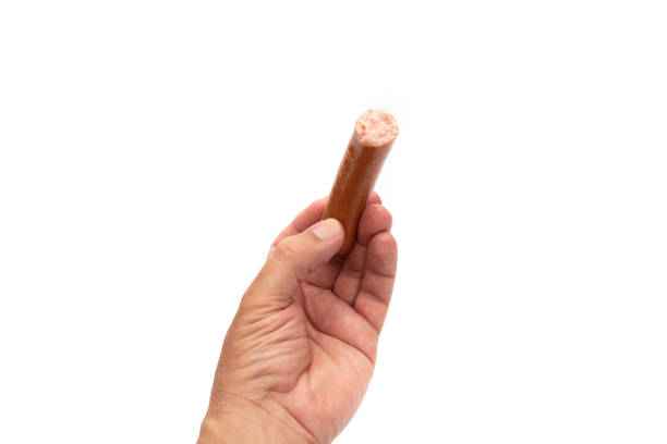 istock A hand holding a sausage, Bockwurst, the tip nibbled off 1392538183