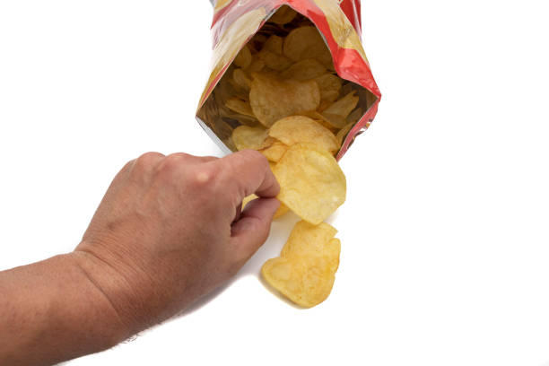 istock A hand taking chip from a bag of chips, open and front view 1392538300