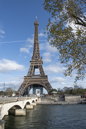 The Eiffel tower from the river Seine in Paris with a train bridge in front, France