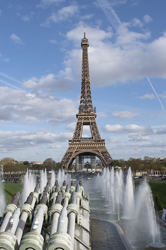 Wide angle view of Eiffel Tower Paris France captured against a clear blue sky framed by Fontaine du Jardin du Trocadéro