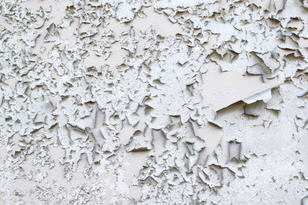 istock Old gray paint peeling from wall texture background. Cracked paint on metallic background 1392538728