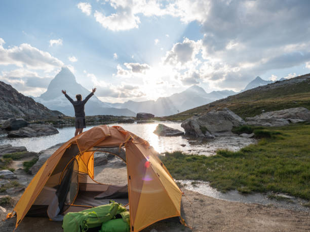 istock Man camping on mountain top, arms wide open 1392538808