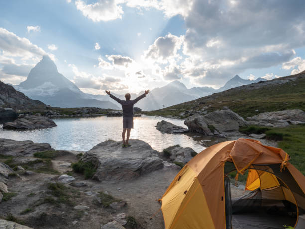 istock Man camping on mountain top, arms wide open 1392538815