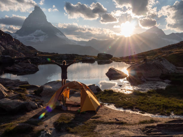 istock Man camping on mountain top, arms wide open 1392539944