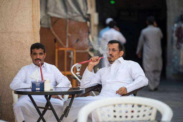 Doha,Qatar - April 15,2022 : Qatari locals in traditional attire hang out in old bazaar market Souk Waqif.