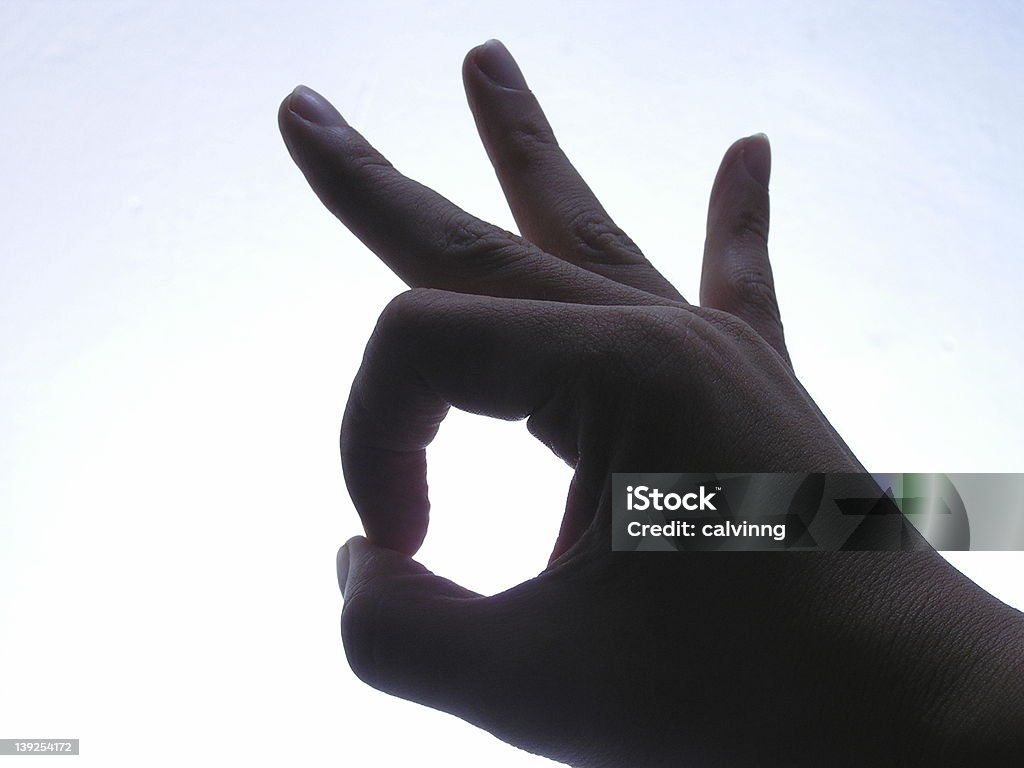 hand sign: okay hand with OK gesture silhoutte (almost, faintly lit) <br> You may also like to consider  these: <br><a href='http://www.istockphoto.com/file_closeup.php?id=222446'><img src='http://www.istockphoto.com/file_thumbview_approve.php?size=1&id=222446' border='0'></a> Agreement Stock Photo