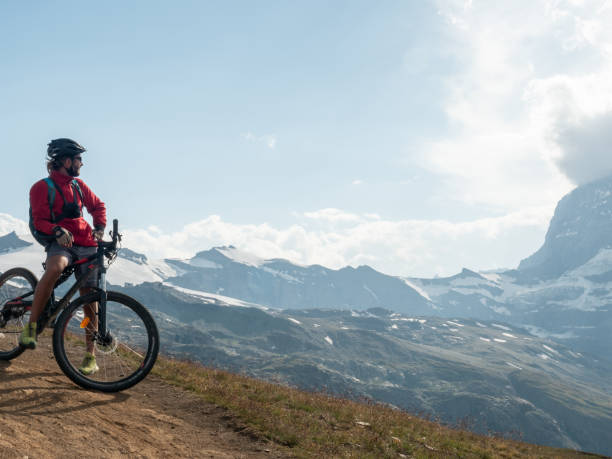 istock Male mountain biker admire the view from bicycle trail, Switzerland 1392543796