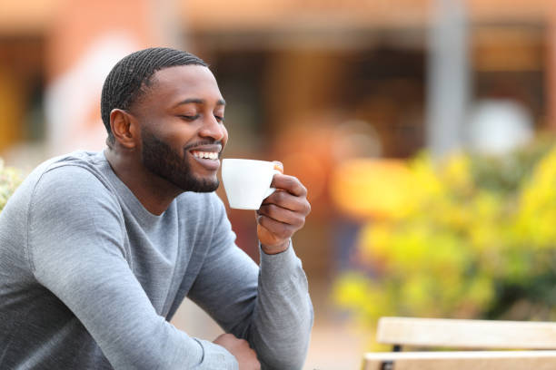 istock Happy man with black skin drinking coffee in a bar 1392543813