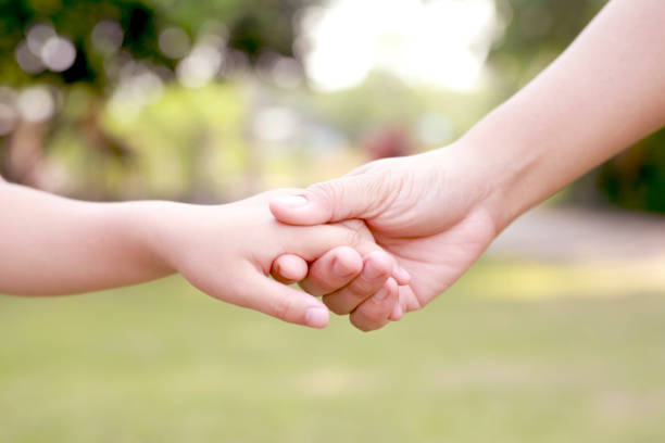 istock Children's hands with care, concern, warmth of mothers. 1392545247