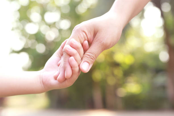 istock Children's hands with care, concern, warmth of mothers. 1392545280