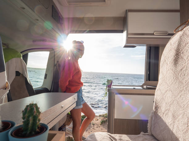 istock Woman in her van looking at ocean 1392545771