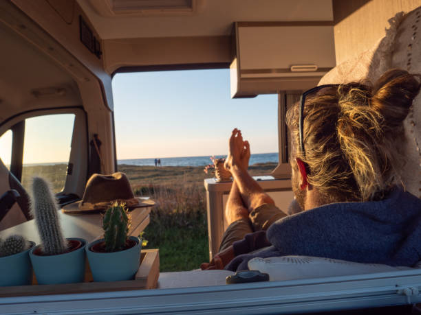 istock Man lying in a van looking at ocean 1392545966