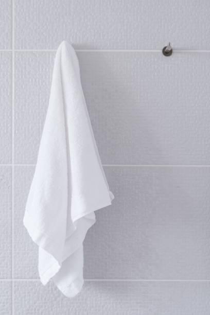 istock Clean white towel hanging on wall in bathroom 1392546648