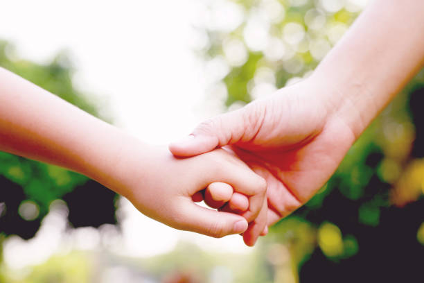 istock Children's hands with care, concern, warmth of mothers. 1392546673