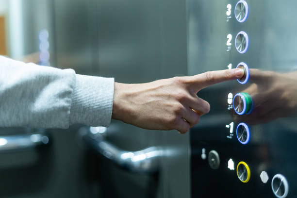 Person selecting first floor being in elevator Closeup of person's hand pushing button to select first floor in elevator. Passenger lift. Businessman in office. Movement within building concept hand elevator stock pictures, royalty-free photos & images