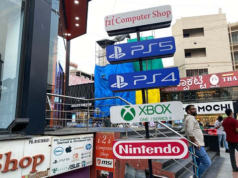 Bangalore, Karnataka. India - April 2022: Video game consoles like Nintendo, PS4 and Xbox advertised outside a computer store in Brigade Road in Bangalore.