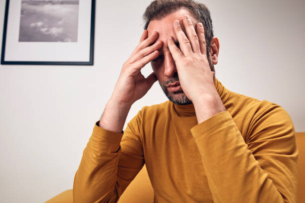 istock Man with headcahe pain, anxiety, depression, sadness at home. 1392550347