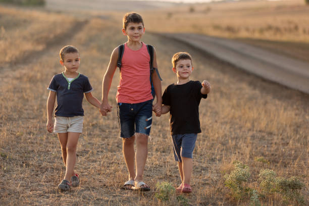 three boys, one older than the rest, doing a radial hike outdoors, lifestyle