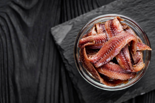 istock canned anchovy fillet on a black wooden rustic background 1392551020