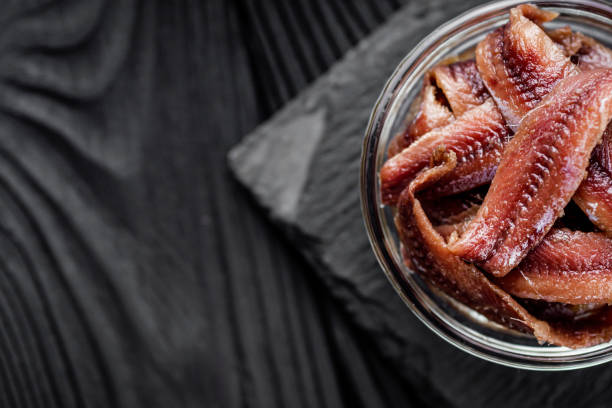 istock canned anchovy fillet on a black wooden rustic background 1392551137