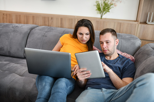 Cute Couple Relaxed While Creating Digital Marketing Strategy Together On Laptop And Digital Tablet