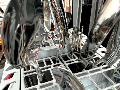 Spoons, cables and knives in a stand for the dishwasher.