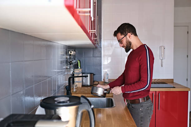 istock Young man washing pot in his house 1392560176