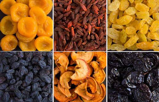 Collage of dried berry and fruit on the black background. Close-up.