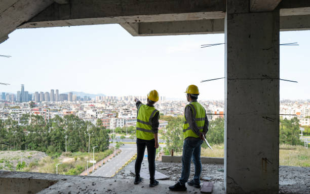istock Male and female civil engineers discussing work on construction site 1392568186